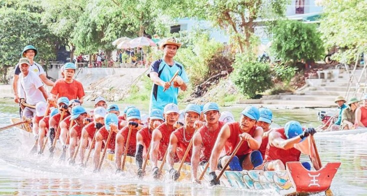 Anh Hoàng Nhật Huy đang đánh mõ trên đội đò bơi xã Tân Thủy.