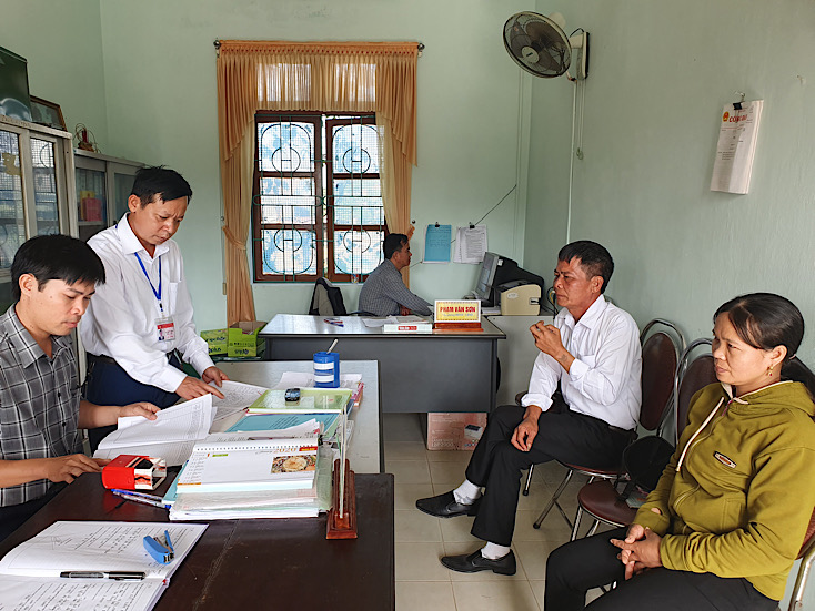 Ông Lê Hữu Bình (người đứng) đang chỉ đạo cán bộ giải quyết thủ tục hành chính cho người dân.