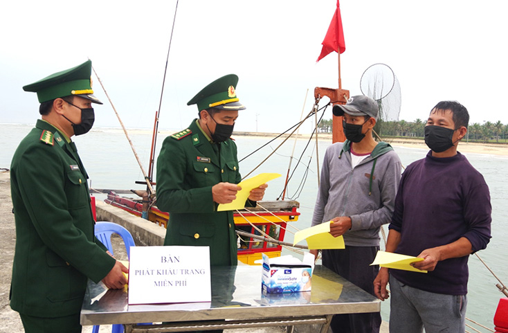 Cán bộ Trạm kiểm soát, Đồn BP Nhật Lệ tuyên truyền, phát khẩu trang miễn phí phòng, chống vi rút Covid-19 cho ngư dân. 