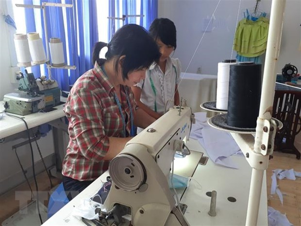 Hướng dẫn cho học sinh học nghề may tại Nhà xã hội Long Hải. (Ảnh: Hoàng Nhị/TTXVN)