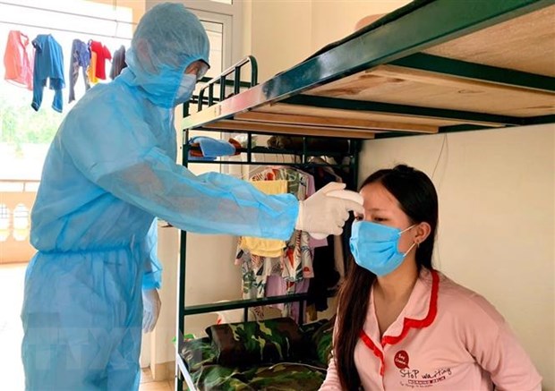 Đo thân nhiệt cho người dân trong khu cách ly trường quân sự Sơn Tây. (Ảnh: TTXVN phát)