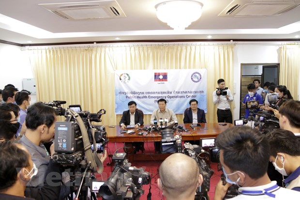  Thứ trưởng Bộ Y tế Lào (giữa), ông Phouthone Meuangpak, thông báo về những ca nhiễm COVID-19 đầu tiên tại nước này. (Ảnh: Phạm Kiên/Vietnam+)