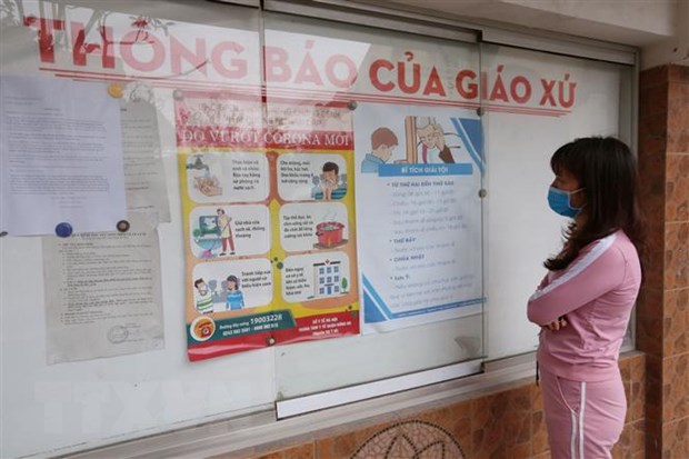 Một giáo dân xem các thông tin về dịch COVID-19. (Nguồn: TTXVN)