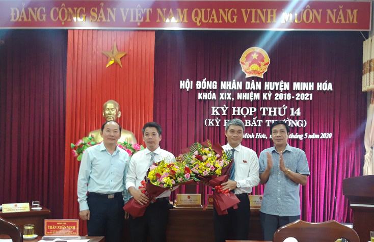 Các đồng chí Trần Xuân Vinh Ủy viên Ban Thường vụ Tỉnh ủy, Trưởng Ban Tổ chức Tỉnh ủy; Nguyễn Công Huấn, Ủy viên Ban Thường vụ Tỉnh ủy, Phó Chủ tịch HĐND tỉnh tặng hoa chúc mừng tân Bí thư Huyện ủy và Chủ tịch UBND huyện Minh Hóa.