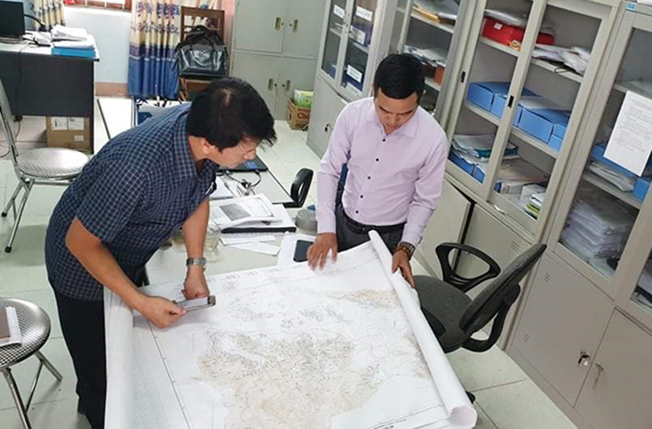 Cán bộ địa chính xã Quảng Hợp trao đổi với phóng viên Báo Quảng Bình về hiện trạng đất đai trên địa bàn.