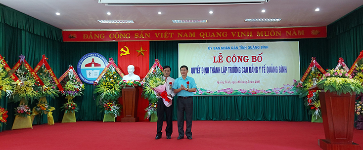 Đồng chí Trần Tiến Dũng, Phó Chủ tịch UBND tỉnh  trao Quyết định thành lập Trường Cao đẳng Y tế Quảng Bình cho đồng chí Lê Viết Hùng, Quyền hiệu trưởng nhà trường