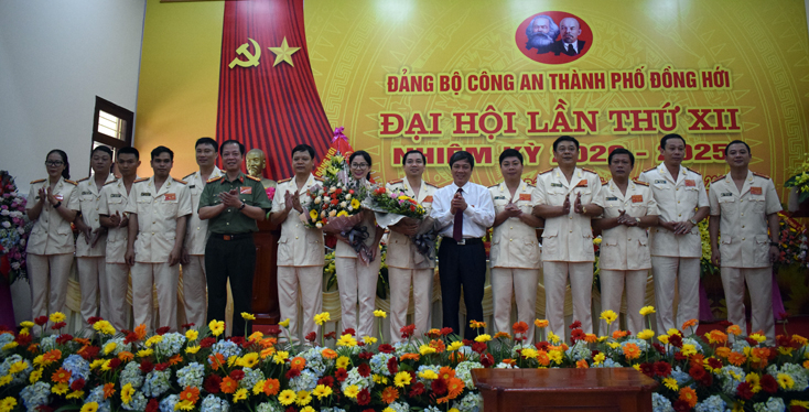 Các đồng chí Ủy viên Ban Thường vụ Tỉnh ủy: Trần Hải Quân, Giám đốc Công an tỉnh và Lê Văn Phúc, Bí thư Thành ủy Đồng Hới tặng hoa chúc mừng Ban Chấp hành Đảng bộ Công an TP. Đồng Hới lần thứ XII, nhiệm kỳ 2020-2025.