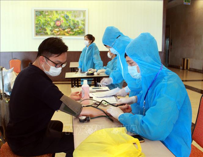  Kiểm tra sức khoẻ người cách ly phòng dịch COVID-19. Ảnh: TTXVN