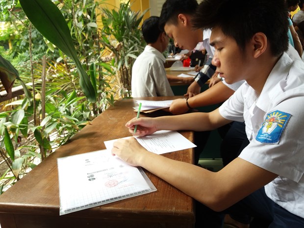 Thí sinh làm hồ sơ xét tuyển đại học. (Ảnh: Phạm Mai/Vietnam+)