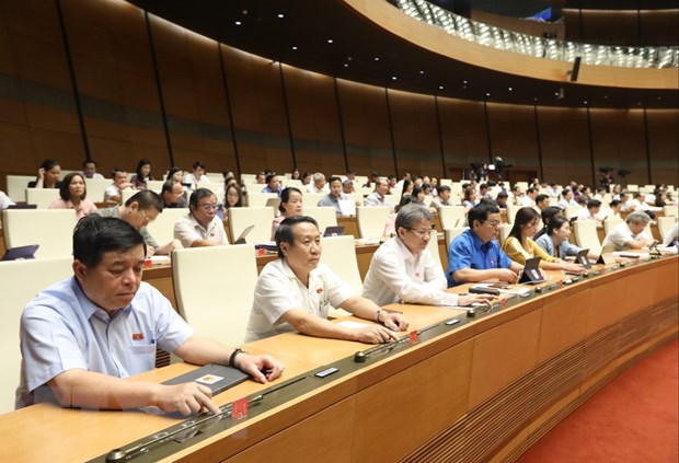 Các đại biểu Quốc hội biểu quyết thông qua Luật sửa đổi, bổ sung một số điều của Luật Phòng, chống thiên tai và Luật Đê điều. (Ảnh: Văn Điệp/TTXVN)