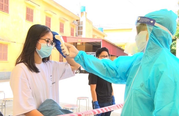 Bác sỹ kiểm tra thân nhiệt cho công dân. (Ảnh: Đinh Tuấn/TTXVN)