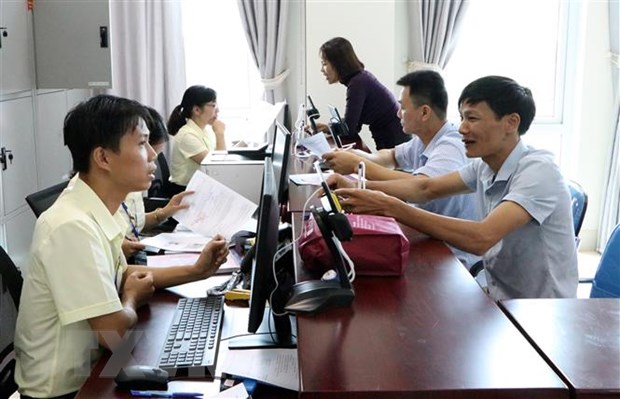 Cán bộ tiếp nhận hồ sơ, giải quyết thủ tục hành chính. (Ảnh: Việt Hoàng/TTXVN)