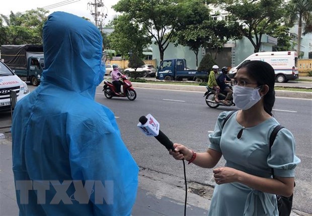  Phóng viên Mỹ Hà của kênh truyền hình Thông tấn Vnews trong một lần tác nghiệp về COVID-19. (Ảnh: Quốc Dũng/TTXVN)