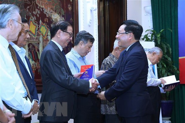 Phó Thủ tướng, Bộ trưởng Bộ Ngoại giao Phạm Bình Minh trao sách tặng các nguyên lãnh đạo Chính phủ và Bộ Ngoại giao. (Ảnh: Lâm Khánh/TTXVN)