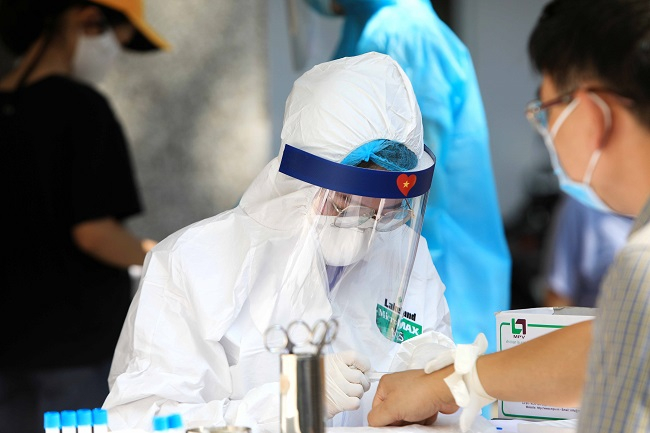  Nhân viên Y tế lấy mẫu máu test nhanh cho người dân. Ảnh: Thành Đạt – TTXVN
