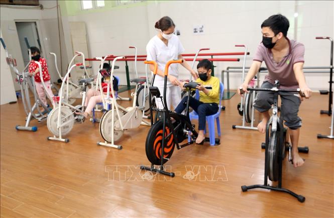  Cán bộ Trung tâm hướng dẫn trẻ em và người lớn khuyết tật vận động tại phòng phục hồi chức năng. Ảnh minh họa: Anh Tuấn/TTXVN
