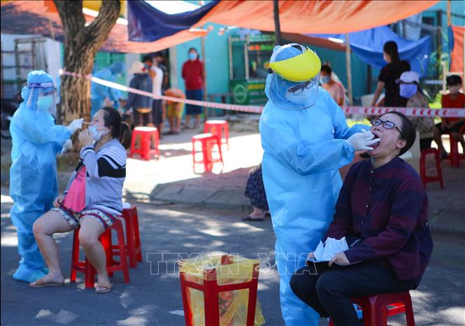  Lấy mẫu xét nghiệm COVID-19 cho người đi từ vùng dịch về. Ảnh: TTXVN