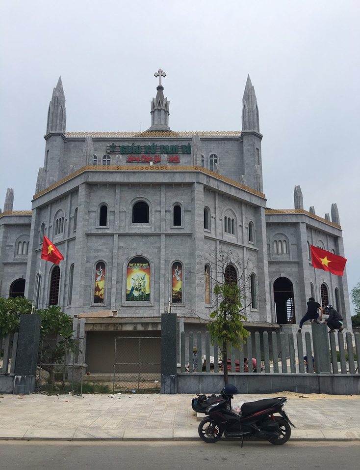 Cờ Tổ quốc tung bay ngay trong khuôn viên viên giáo xứ Tam Tòa.