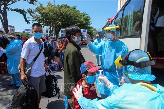 Kiểm tra thân nhiệt người dân, phòng dịch COVID-19 khi tham gia giao thông. Ảnh: TTXVN.