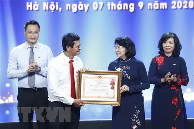 Phó Chủ tịch nước Đặng Thị Ngọc Thịnh, Phó Chủ tịch thứ nhất Hội đồng Thi đua-Khen thưởng Trung ương trao Huân chương Lao động hạng Nhất của Chủ tịch nước cho tập thể Đài Truyền hình Việt Nam. (Ảnh: Dương Giang/TTXVN)
