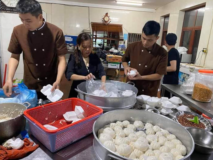 Ai cũng tất bật, vội vã để mang những suất ăn nóng hổi tới người dân vùng lũ. Ảnh: FB Hoàng Bùi