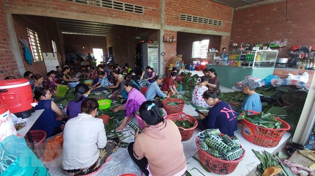 Người dân gói bánh tét ủng hộ đồng bào miền Trung. (Ảnh: TTXVN)