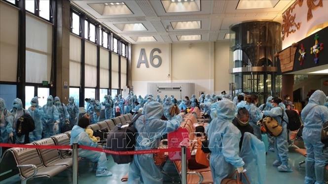Các công dân Việt Nam làm thủ tục lên máy bay về nước. Ảnh: TTXVN phát