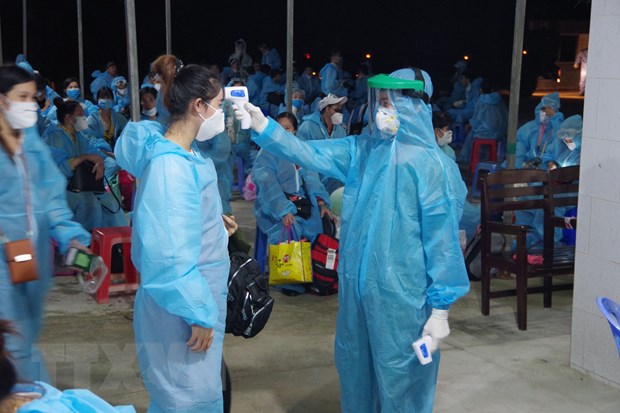 Đo thân nhiệt cho công dân trước khi tiếp nhận. (Ảnh: Chanh Đa/TTXVN)