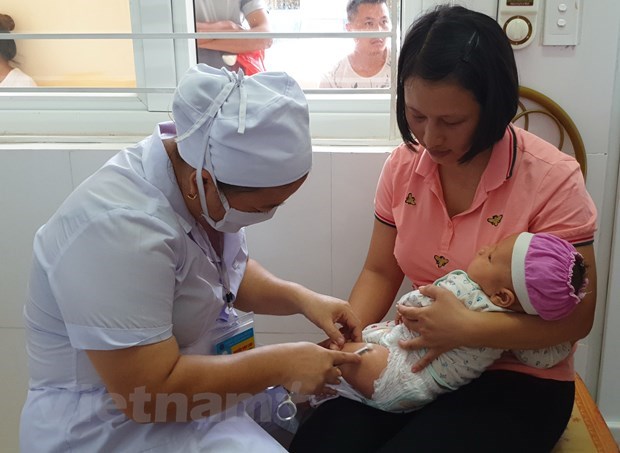  Nhân viên y tế tiêm chủng cho trẻ nhỏ. (Ảnh: T.G/Vietnam+)