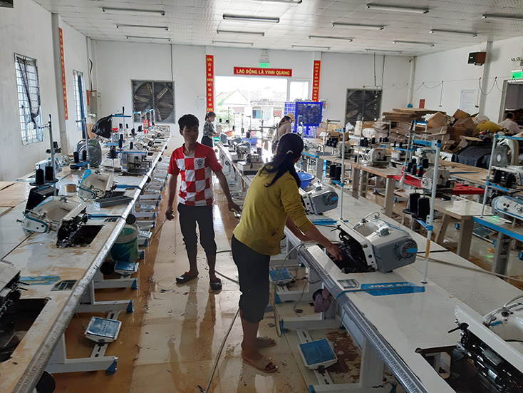 Công nhân Công ty TNHH ĐVH dọn dẹp xưởng may sau lũ lụt.