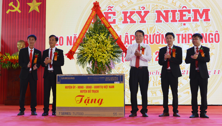 Đại diện lãnh đạo huyện Bố Trạch tặng hoa và quà chúc mừng thầy và trò Trường THPT Ngô Quyền.