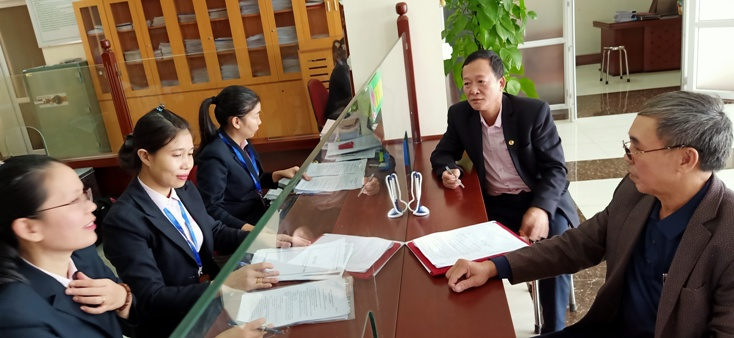 Doanh nghiệp được cán bộ tín dụng NHCSXH nhiệt tình hướng dẫn và tư vấn làm thủ tục vay vốn trả lương cho lao động bị ngừng việc bởi dịch Covid-19.