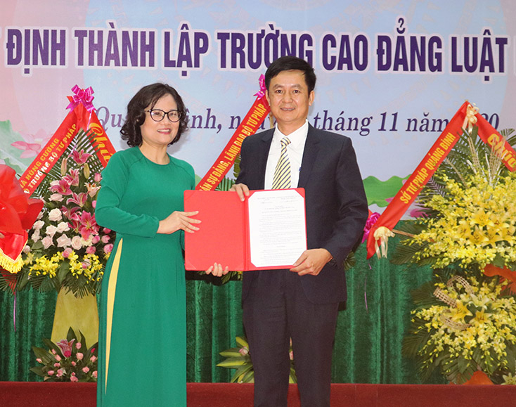 Đại diện lãnh đạo Tổng cục Giáo dục nghề nghiệp, Bộ Lao động-thương binh và xã hội trao quyết định thành lập Trường Cao đẳng Luật miền Trung.