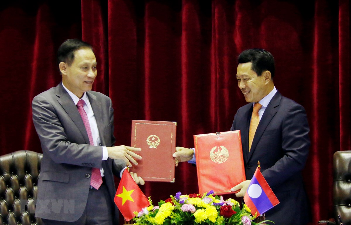 Thứ trưởng Bộ Ngoại giao Lê Hoài Trung và Bộ trưởng Ngoại giao Lào Saleumsay Kommasith đang trao đổi Biên bản cuộc họp. (Ảnh: Phạm Kiên/TTXVN)