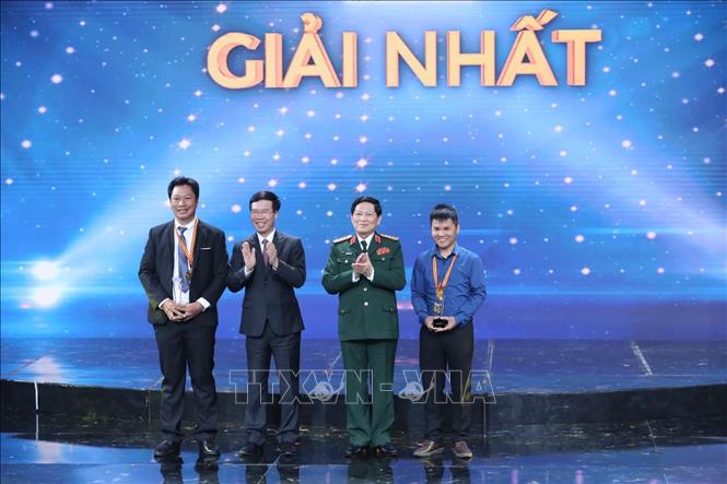 Đồng chí Võ Văn Thưởng, Uỷ viên Bộ Chính trị, Trưởng Ban Tuyên giáo Trung ương, đồng chí Ngô Xuân Lịch, Uỷ viên Bộ Chính trị, Bộ trưởng Bộ Quốc Phòng trao giải Nhất cho 2 tác giả đoạt giải. Ảnh: Minh Quyết/TTXVN
