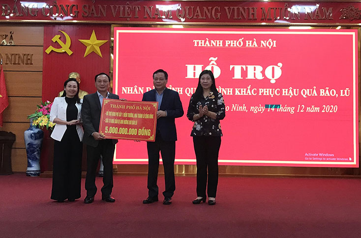 Các đồng chí: Phó Bí thư Thành ủy Hà Nội Nguyễn Văn Phong, Phó Chủ tịch Ủy ban Trung ương MTTQVN Nguyễn Lan Hương trao biển tượng trưng hỗ trợ 5 tỷ đồng cho tỉnh Quảng Bình
