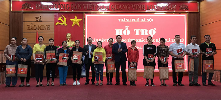 Đồng chí Phó Bí thư Thành ủy Hà Nội Nguyễn Văn Phong và đồng chí Phó Bí thư Thường trực Tỉnh ủy Quảng Bình Trần Hải Châu tặng quà cho các hộ dân thuộc nghiệp đoàn nghề cá xã Bảo Ninh
