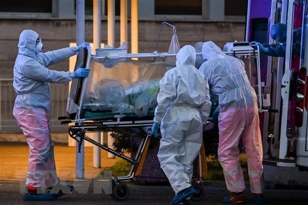 Nhân viên y tế chuyển bệnh nhân nhiễm COVID-19 tới bệnh viện ở Rome, Italy. (Ảnh: AFP/TTXVN)