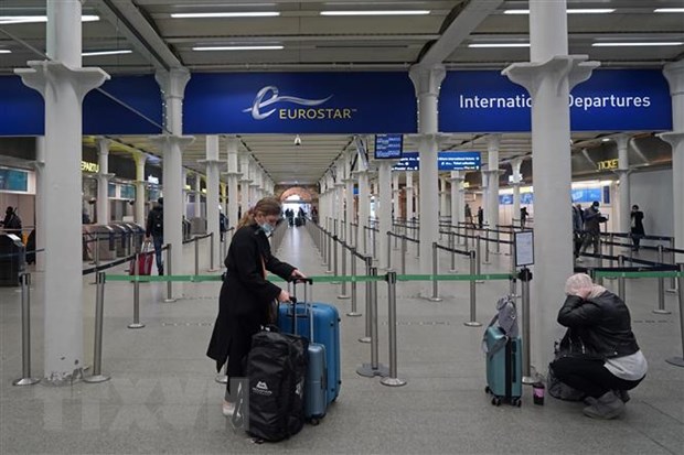  Hành khách đeo khẩu trang phòng lây nhiễm COVID-19 tại nhà ga quốc tế ở London, Anh, ngày 20-12-2020. (Ảnh: AFP/TTXVN)