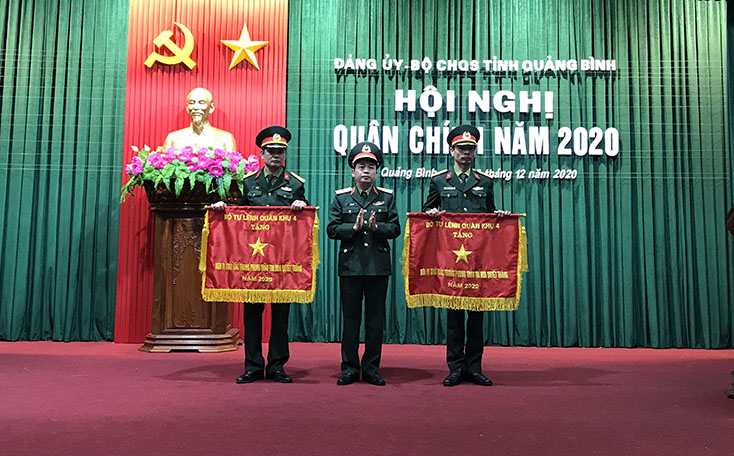 Đại diện lãnh đạo Bộ Tư lệnh Quân khu 4 trao cờ đơn vị xuất sắc trong phong trào thi đua quyết thắng năm 2020 cho các tập thể.