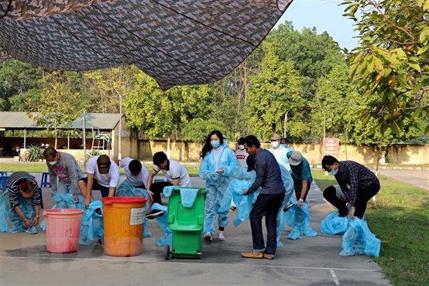 Công dân về từ nước ngoài bỏ đồ bảo hộ y tế để tập trung. (Ảnh: Thanh Hải/TTXVN)