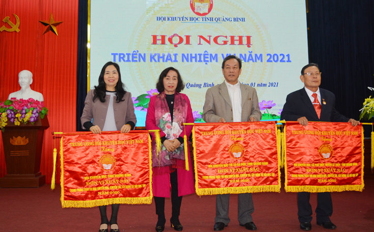 Chủ tịch Hội Khuyến học tỉnh Phạm Thị Bích Lựa trao Cờ thi đua xuất sắc của Trung ương Hội Khuyến học Việt Nam tặng 3 tập thể.