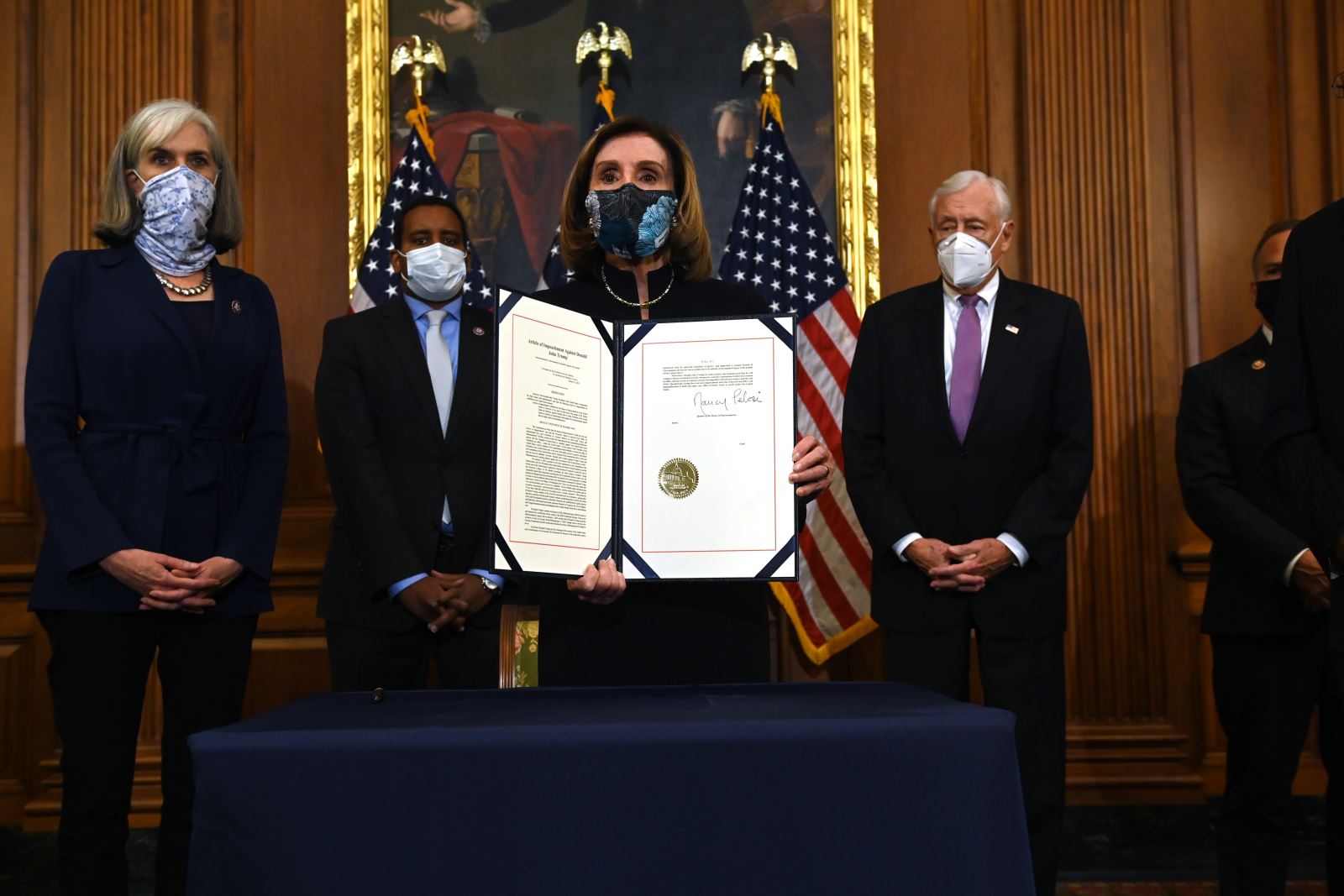Chủ tịch Hạ viện Mỹ Nancy Pelosi (giữa) cùng các quan chức Hạ viện công bố điều khoản luận tội Tổng thống Donald Trump được Hạ viện thông qua ngày 13/1/2021. Ảnh: AFP/TTXVN