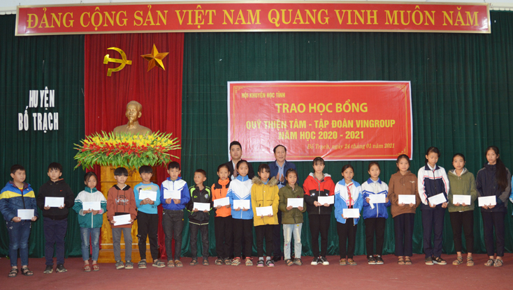 Đại diện lãnh đạo Hội Khuyến học tỉnh và nhà tài trợ trao học bổng cho học sinh huyện Bố Trạch.