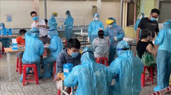 Cán bộ y tế của Trung tâm y tế Quận 1 lấy mẫu xét nghiệm tầm soát cho người dân khu vực Mả Lạng, Phường Nguyễn Cư Trinh, Quận 1. Ảnh: Đinh Hằng/TTXVN
