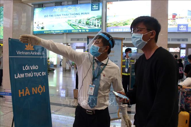  Các nhân viên hướng dẫn hành khách đến khu vực làm thủ tục lên máy bay. Ảnh: Tiến Lực/TTXVN