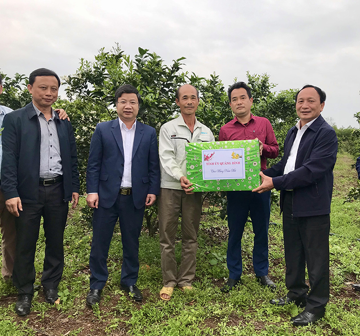 Đồng chí Phó Bí thư Thường trực Tỉnh ủy Trần Hải Châu tặng quà động viên hộ nông dân trồng cam.