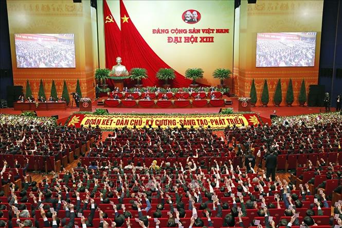 Các đại biểu biểu quyết, thông qua Nghị quyết Đại hội XIII của Đảng. Ảnh: TTXVN
