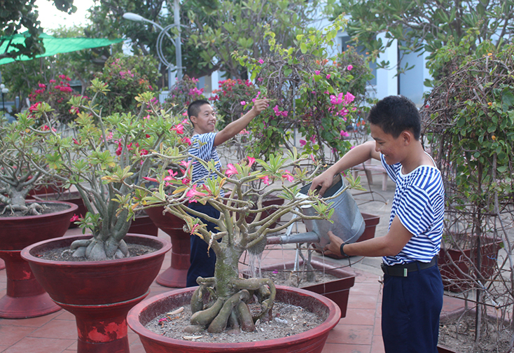 Binh nhất Bùi Đình Hợp (bên phải) cùng đồng đội trên đảo Trường Sa Lớn làm đẹp cây cảnh.