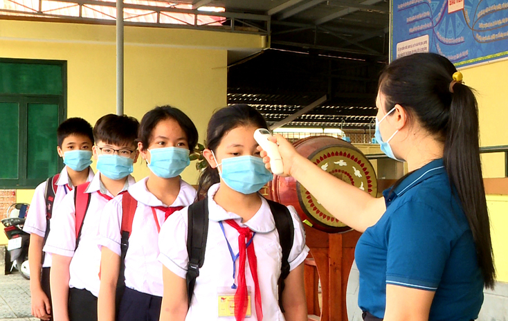 Các em học sinh được kiểm tra thân nhiệt mỗi khi đến lớp.